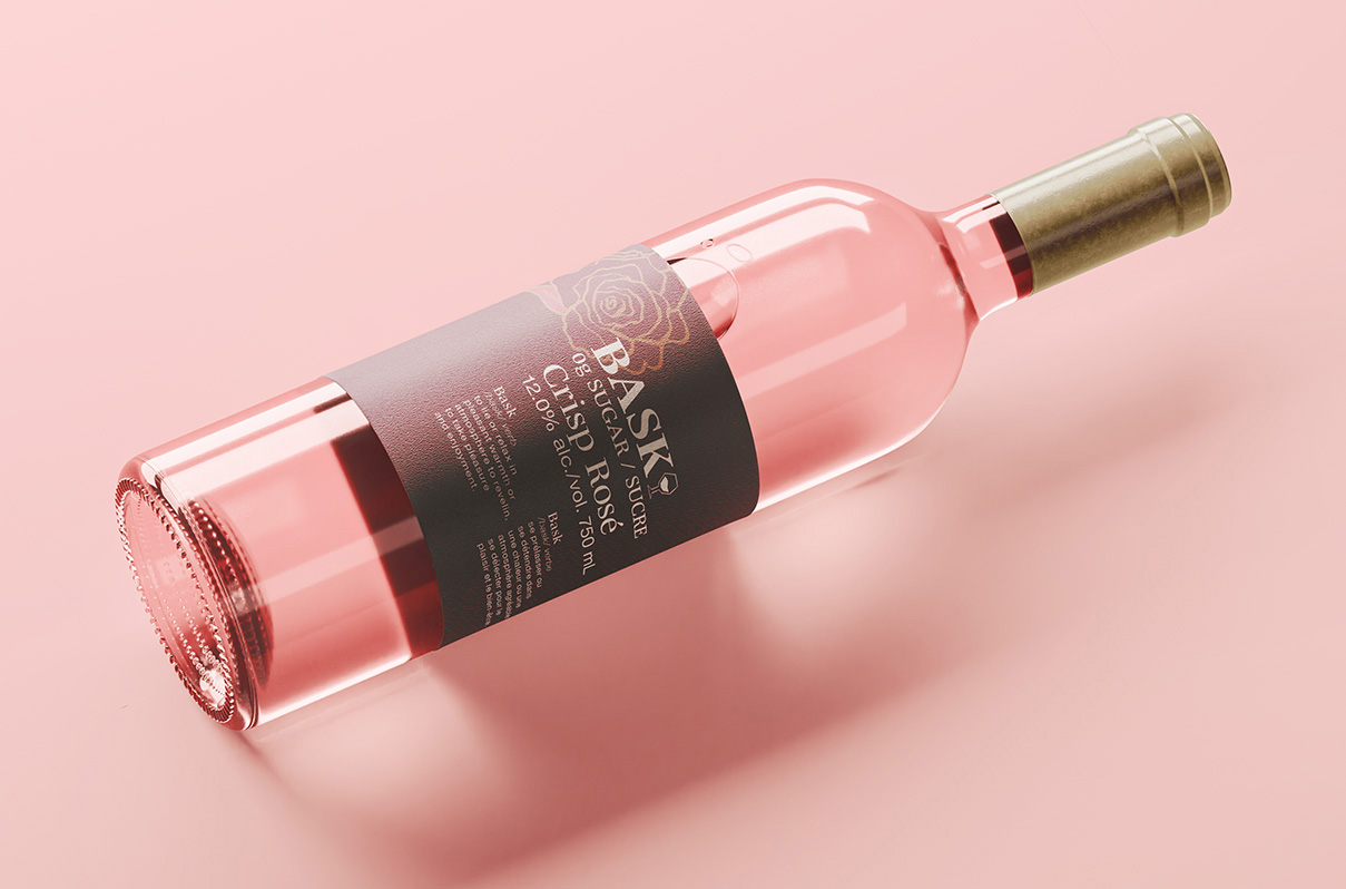 A pink wine bottle with the new BASk Rose redesigned label on it
